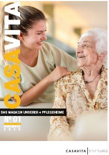 Titelbild der ersten Ausgabe des Casavita Magazins: Eine stehende Pflegeperson hat die eine Hand auf die Schulter einer sitzenden Bewohnenden gelegt, sie schauen sich lächelnd an.