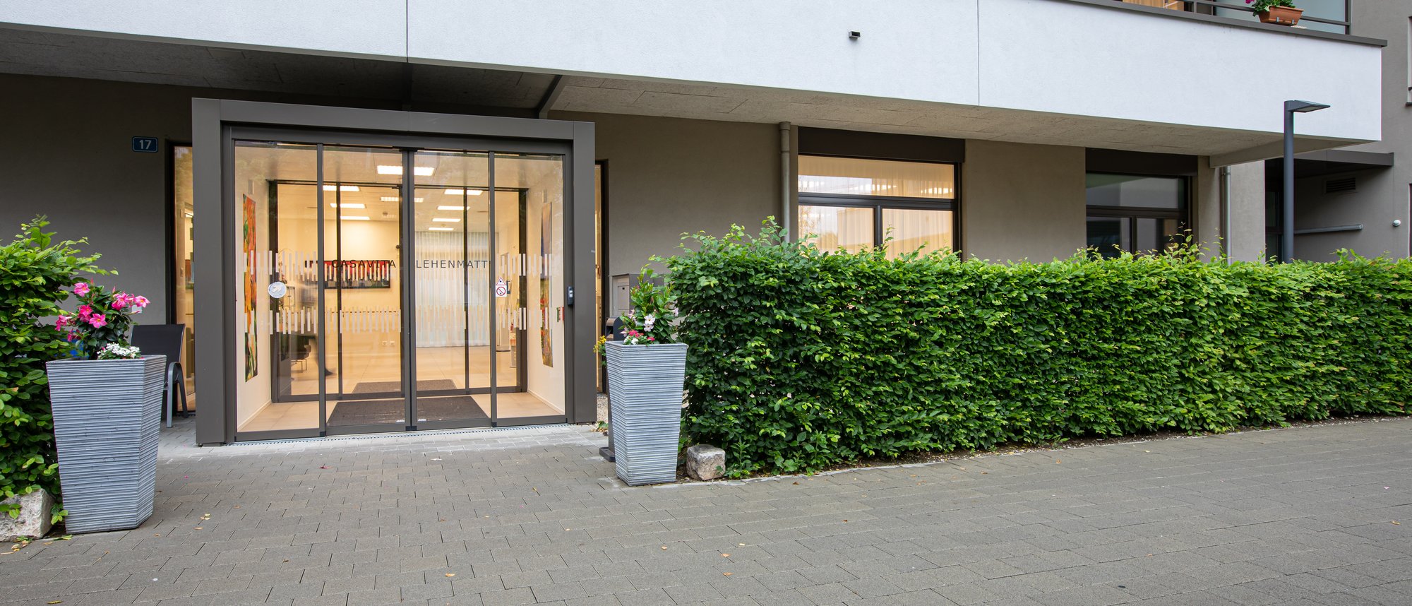 Eine Momentaufnahme des Einganges der Casavita Lehenmatt ist sichtbar.